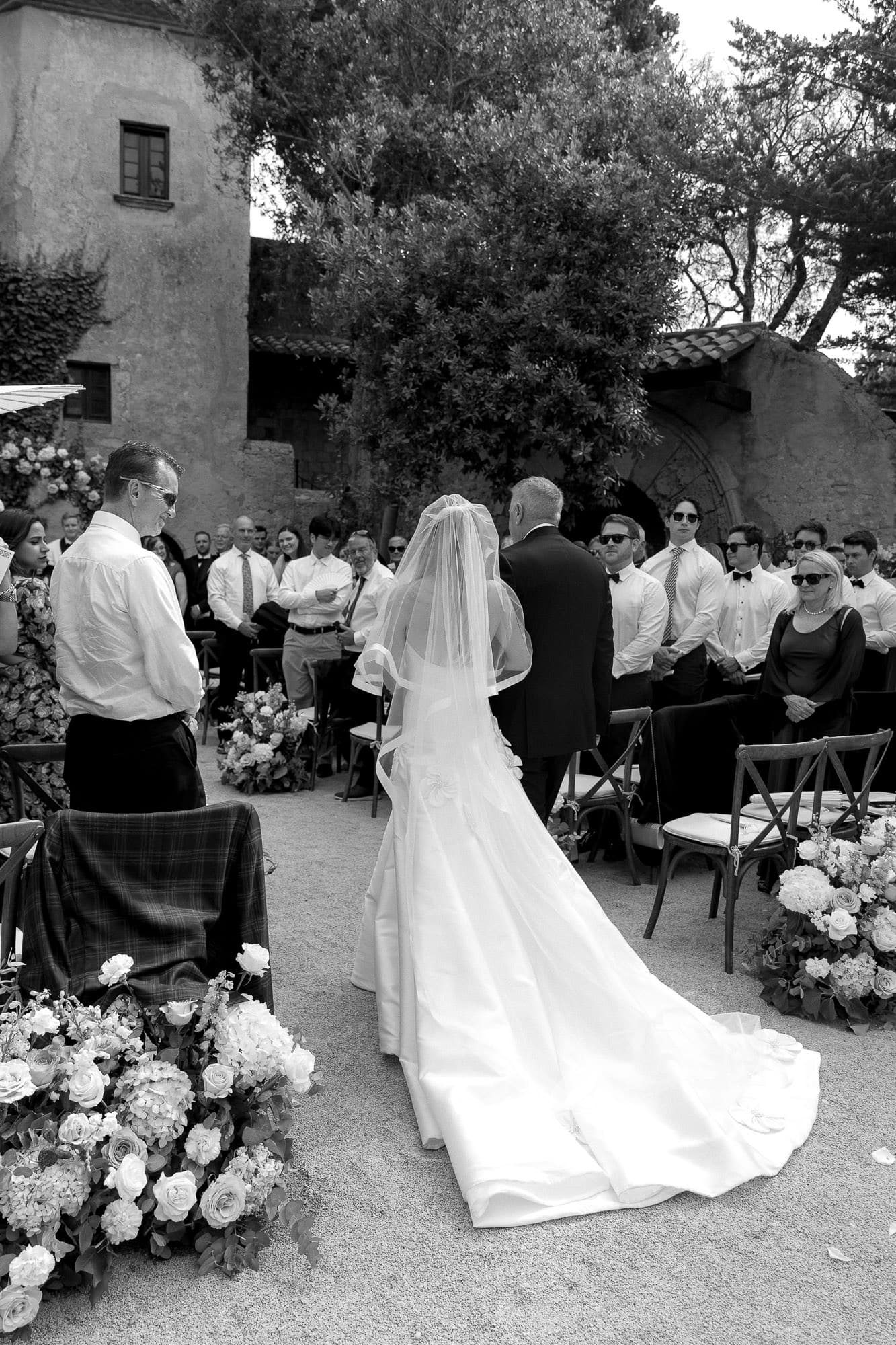Novia entrando en la ceremonia en su boda mediterránea en Barcelona. Catell de Tamarit